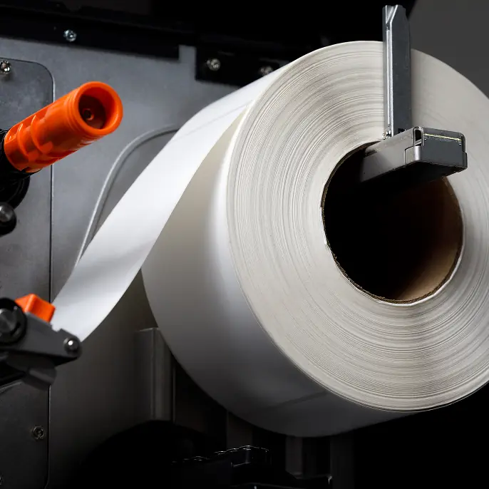 Orange LPN barcode label on cardboard box with hand holding it