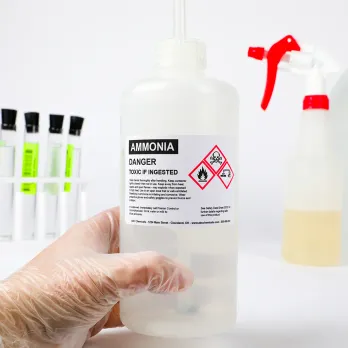 Hand holding a labeled bottle of ammonia