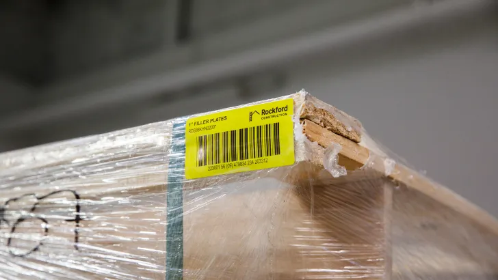 Shrink-wrapped lumber with yellow LPN label attached