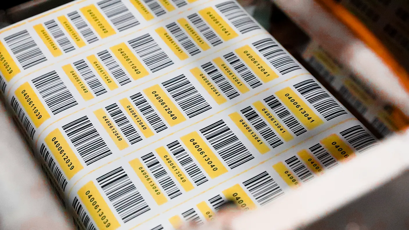 a sheet of labels coming out of a press