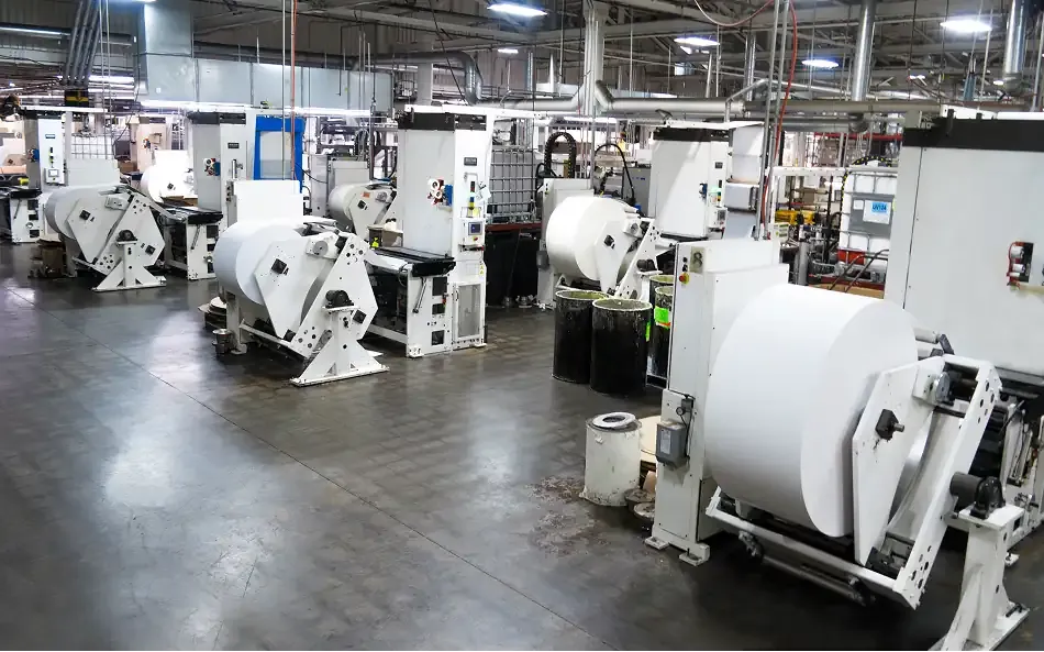 A wide view of several large manufacturing machines in a plant factory setting