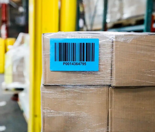 a shrinkwrapped pallet of cardboard boxes with blue and green labels on the side