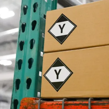 Stack of cardboard boxes with green shipping label displaying number 09 and tracking barcode