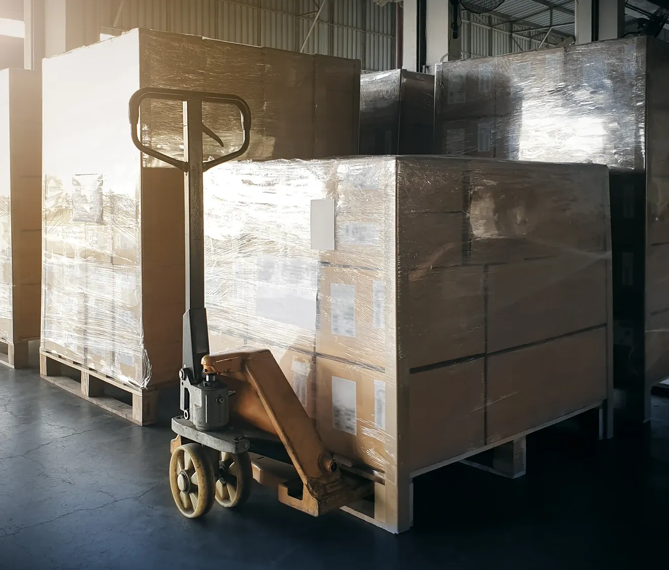 a forklift raising a pallet of boxes high above warehouse shelves 