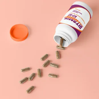 Medication bottle with pills scattered on surface