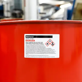 Roll of white thermal labels with QR codes wrapped around stainless container
