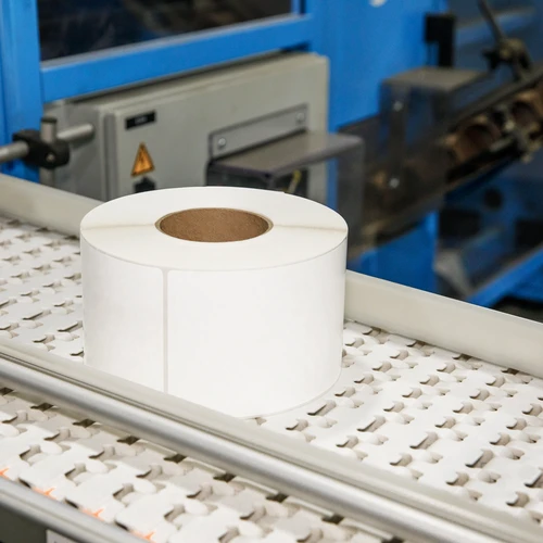 worker operating industrial printing equipment in manufacturing facility