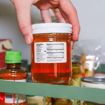 Hand holding a glass jars with nutrition label