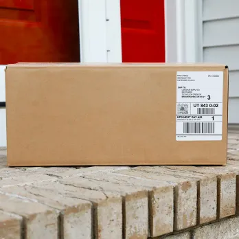a labeled cardboard box on the front stairs of a house