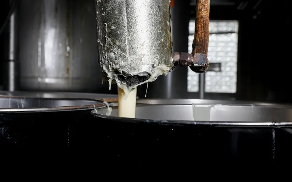 Close-up of adhesive application nozzle during coating process