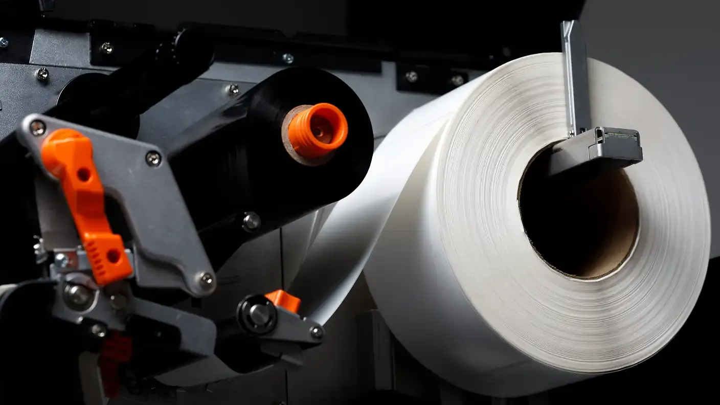 a zebra printer with rolls of thermal labels on either side