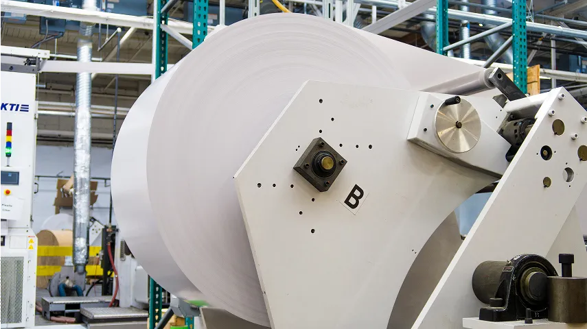 a huge roll of labels on a printing press